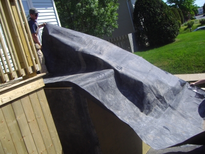 Wrapping the 6' by 8' shed in the surplus rubber.